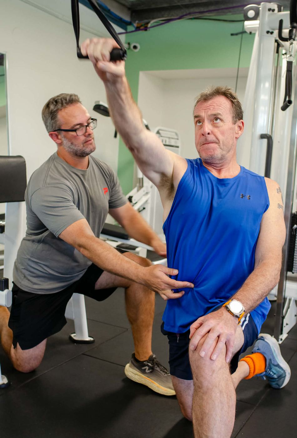Mathew cueing a client's trunk position during a half-kneeling cable pulldown