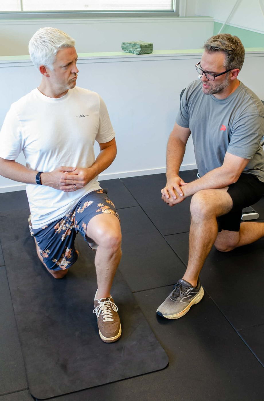Mathew and a client in a half-kneeling position, working through a trunk rotation drill
